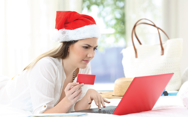 Woman shopping for the holidays on laptop with caution